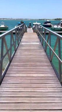 Rıhtımlara doğru yürürken limanın huzurlu ve sakin atmosferini vurgulayarak rahatlama ve manzaralı güzellik macerası üzerine odaklanmış tekneler rıhtıma yanaştı.