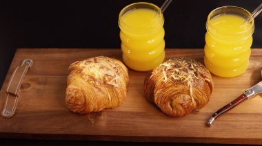 Golden croissants paired with two yellow drinks Handcrafted pastries and cool drinks evoke sunny morning, emphasizing homemade comfort. clipart