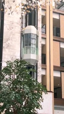  5 yıldızlı oteldeki cam asansör kabini modern tasarım ve tavandan sarkan karmaşık dekorasyonlarla sarmalanmış lüks ve çağdaş tarzda misafir deneyimini geliştiriyor.