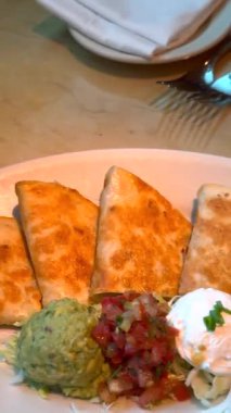 Gurme quesadilla kremalı avokado, taze domates salatası ve ekolojik malzemelerden yapılan zengin sosla eşleştirilerek modaya uygun bir kafede lezzetli yemek deneyimi sunuluyor..