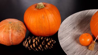 Pumpkins with broom, orange, pinecones evoke Halloween festive charm indoors. Vibrant autumn elements create warm rustic setting, embracing seasonal decor, ideal for cozy festive gatherings. clipart