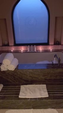 Otel banyosunda mum ışığında su, baloncuk ve romantik mumlar. Doğulu stil ve sakin ortam huzurlu ve lüks bir banyo deneyimi yaratıyor. Şık Doğu Kaplıcası kavramı hariç.