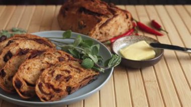 İçinde domates ve zeytin pişirilmiş dilimlenmiş ekmek, vegan tereyağı, acı biber ve taze yeşilliklerle birlikte. Akdeniz 'den esinlenilmiş vejetaryen yemeği bitkisel güzelliklerle dolu sağlıklı bir çevre dostu seçenektir. 