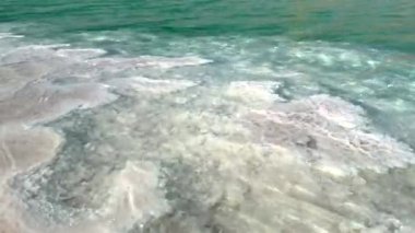 Sert tuz birikintileri berrak suyla buluşur, doğal dokular yumuşak güneş ışığı altında karışır, kaba tuz oluşumları ve pürüzsüz, şeffaf su arasındaki zıtlığı artırır..