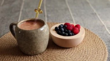 Yaban mersininin renkli bir karışımı, ahududu ahşap kasede portakal suyu ve doğal dokuma hasırı, çevre dostu, besin zengini sağlıklı yaşam için sağlıklı atıştırmalıkları teşvik eder..