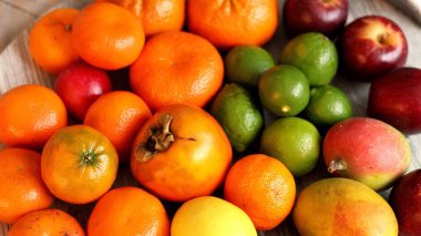 Hurma, mango, limon, elma içeren meyveler, canlı sonbahar hasadında eko bolluğunu vurgular. Taze renkli ekran, eko çilek ve narenciye içeren doğal davetkar atmosfer sunar..