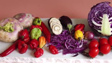 Kırmızı biberler, şalgam, patlıcan, dilimlenmiş mantar ve mor lahana gösterişli ekolojik çeşitlilikte karışık sebzeler. Organik tazelik, canlı ve sağlıklı yaşam tarzını vurgular..