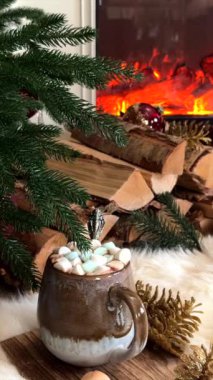 Noel atmosferi, kozalakların, yeşilliklerin ve yakacak odunların arasına yerleştirilmiş seramik bardakta kakao ile vurgulanarak ormanlık dekor ile rahatlatıcı tatil titreşimleri yaratıyor.. 