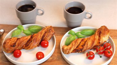  Breakfast setting with two plates featuring golden twist pastries, basil, cherry tomatoes alongside two steaming cups of coffee, evoking warmth, comfort, perfect for cozy morning. clipart