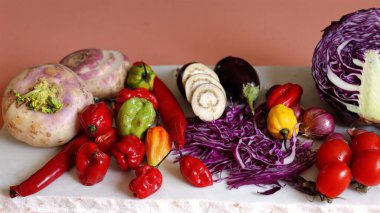 Mixed vegetables featuring red peppers, turnips, eggplant, sliced mushrooms, and purple cabbage showcase eco-friendly variety. Organic freshness emphasizes vibrant healthy lifestyle. clipart