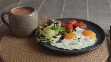 Beyaz yumurtalar üzerinde iki parlak sarı yumurta karışık yeşil salata, nar tohumları, tabakta sıralanmış somon parçaları taze yaşam tarzını vurgulayan canlı sağlıklı bir yemek yaratıyor..