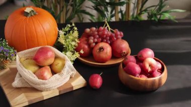 Turuncu balkabağı, pembe üzüm, kırmızı nar ve sarı armut canlı eko hasat görüntüsü yaratır. Doğal ve sağlıklı yaşam tarzı için çevre dostu meyve ve böğürtlen vurgulanıyor.