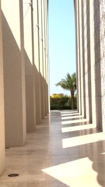 Abu Dhabi, BAE - 9 Eylül 2024: Temiz hatlar, kolonlar, kemerler, güneş ışığıyla yıkanmış ışık ve gölgenin çarpıcı kontrastı, mavi gökyüzü vurgulu parlak 