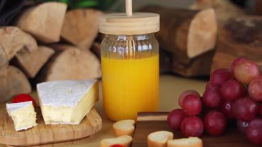 Kaba bir meyve suyu kavanozu, yumuşak peynir ve ahşap yüzeyde taze üzümlerle yayılan brunch, rahatlamanın altını çizer, brunch ilhamı ve konforlu yemek için mükemmeldir..