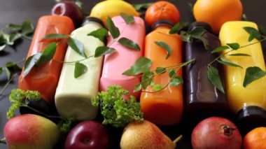 Turuncu sarı ve beyaz tonlarda meyve suyu şişeleri organik sağlığı sembolize eder. Çevresindeki renkli şişeleri çevreleyen eko yaprakları canlı organik ve doğal ürünleri vurguluyor..