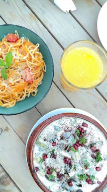 Pasta with fresh herbs from bioFarm paired with creamy salad and juice. Pasta meal showcases fresh herbs and vibrant flavors from bioFarm. Culinary harmony concept. clipart