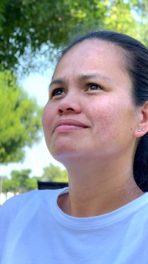 Odaklanmış kadın dışarıda yavaş nefes alıyor, çevresini çevreleyen canlı yeşillikler, besleyici rahatlama, iç sakinlik, sağIık, stres atağı için somut farkındalık, genel sağlık.