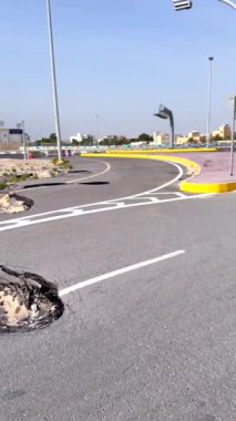 Hasarlı otobanda belirgin bir delik ve birden fazla asfalt çatlağı var. Su ve kum birikimi erozyon, yıpranma ve taşımacılıktaki iklim değişikliğinin yol açtığı riskleri gösteriyor..