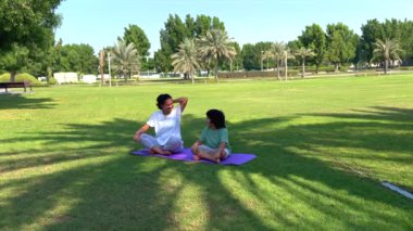Anne-çocuk yogası güneş ışığı altında, park ayarlama sakin egzersiz, aile refahı, sükunet, açık hava sükuneti, bağlı ahenk konsepti.