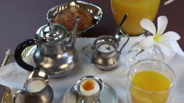  Gümüş çaydanlık ve karışık sofra takımı ile şık kahvaltı kültürel gelenekleri yansıtır. Canlı portakal suyu, kruvasan, haşlanmış yumurta, sütlü küçük valeler, şeker sonsuz mutfak cazibesini arttırır.