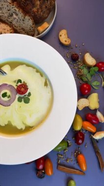 Beyaz kasede servis edilen mercimek çorbası, kiraz domatesli, soğan dilimli ve kır ekmeğiyle çiftleştirilmiş. Sıcak, dünyevi tatlar sağlıklı seçimleri kucaklıyor, nostaljik rahatlığı çağrıştırıyor..