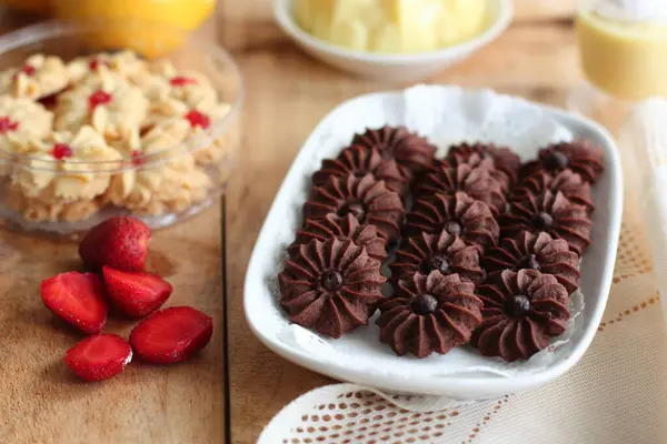 Çikolatalı kurabiye ve limonlu çilekli puding ile ahşap yüzeyde vanilyalı kurabiye.