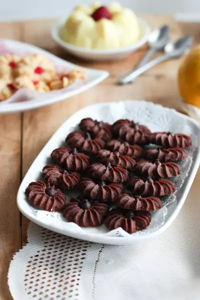 Çikolatalı kurabiye ve limonlu çilekli puding ile ahşap yüzeyde vanilyalı kurabiye.