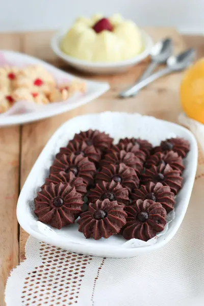 Çikolatalı kurabiye ve limonlu çilekli puding ile ahşap yüzeyde vanilyalı kurabiye.