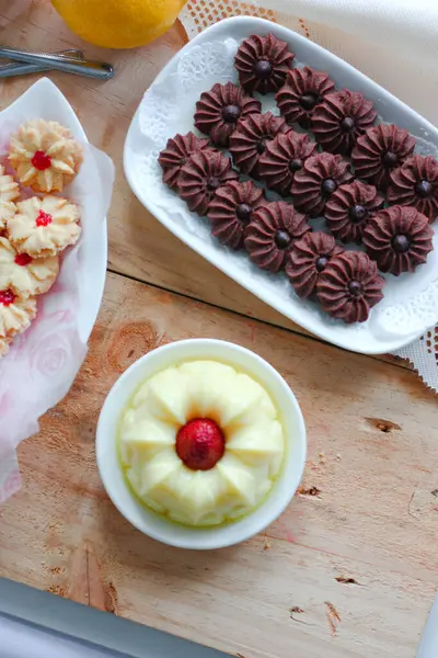Çikolatalı kurabiye ve limonlu çilekli puding ile ahşap yüzeyde vanilyalı kurabiye.