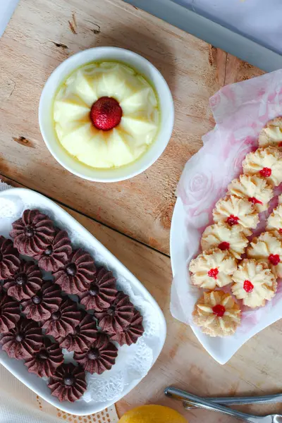 Çikolatalı kurabiye ve limonlu çilekli puding ile ahşap yüzeyde vanilyalı kurabiye.