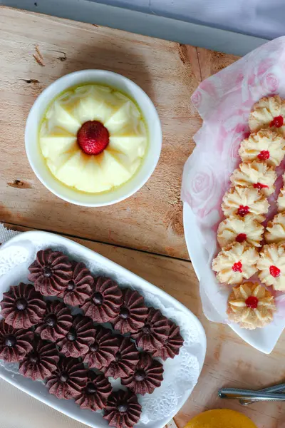 Çikolatalı kurabiye ve limonlu çilekli puding ile ahşap yüzeyde vanilyalı kurabiye.