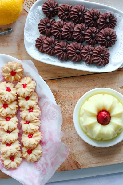 Çikolatalı kurabiye ve limonlu çilekli puding ile ahşap yüzeyde vanilyalı kurabiye.