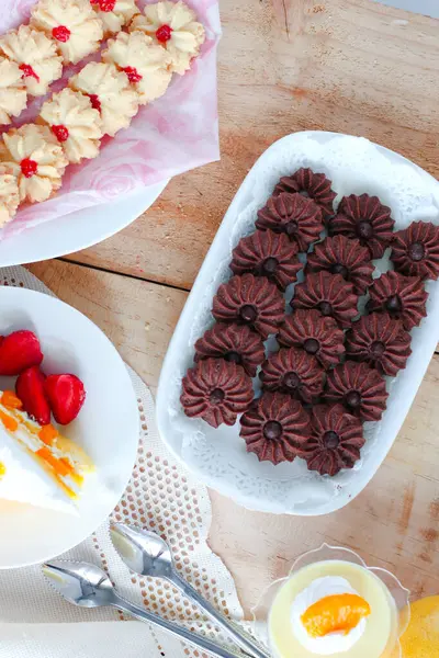 Çikolatalı kurabiye ve limonlu çilekli puding ile ahşap yüzeyde vanilyalı kurabiye.
