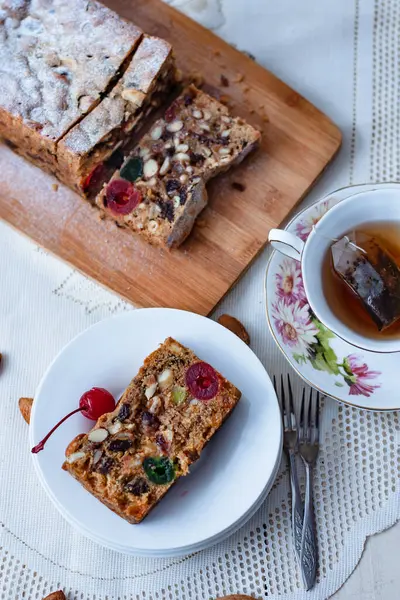 İngiliz meyveli keki, bir somun ekmek ve bir dilim porselen tabak ve bir fincan çay.     