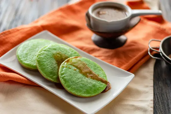 Serabi Pandan, geleneksel pirinç unundan yapılmış Endonezya krepleri, hindistan cevizi sütü ve hurma şekeri sosuyla servis ediliyor.                   