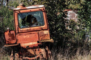 An old tractor forgotten in the grass clipart