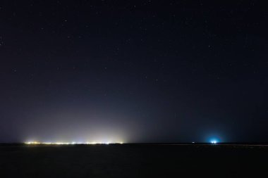 Şehir ışıkları denizin üzerinde gecenin içinde