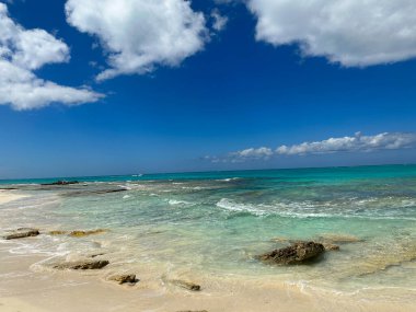 Kayalıklı güzel turkuaz sular ve bulutlu mavi gökyüzü.
