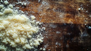 A wooden surface sprinkled with coarse salt and fine powder, sug