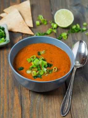 Taze domates çorbası fırınlanmış Pita ekmeği, limon ve taze soğan ahşap bir masada, üst manzara