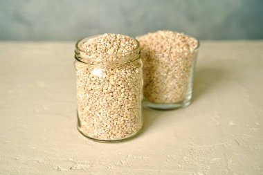 A glass jar filled with pearl barley.