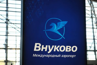 Moskova, Rusya - 09.22.2024: Vnukovo Havaalanı. Terminal binasındaki Vnukovo uluslararası havaalanının amblemi, parlak tahta üzerindeki mavi arkaplanda yeni bir logo
