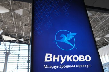 Moskova, Rusya - 09.22.2024: Vnukovo Havaalanı. Terminal binasındaki Vnukovo uluslararası havaalanının amblemi, parlak tahta üzerindeki mavi arkaplanda yeni bir logo