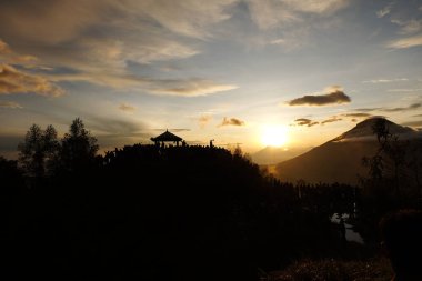 Dieng - Wonosobo, Indonesia - May 29, 2018 People enjoy beautiful Golden Sunrise Sikunir view of the Dieng Wonosobo clipart