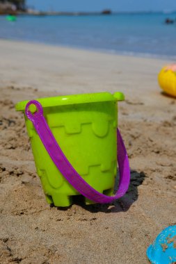 Kumsaldaki çocuklar için renkli plaj oyuncakları seti. Bokeh Manzarası ve Sahilin Arkaplanı,