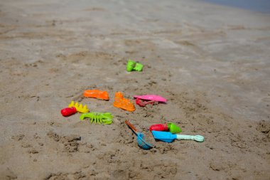 Sahildeki çocuklar için renkli plaj oyuncakları, kale tırmığı ve kürek seti..