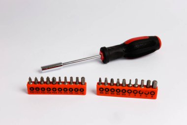 Beyaz arka planda izole edilmiş yerine konulabilir başlıklı tornavidayı kapat, çelikten plastik kırmızı siyah saplı tornavidayı ısır. Çoklu başlık