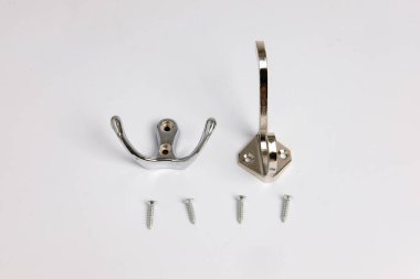 Duvarda paslanmaz çelik çift kancalı askılar asılı duran eşyaları güvenli bir şekilde asmak için kullanılır. Beyaz arka planda izole edilmiş. Boşluğu kopyala.