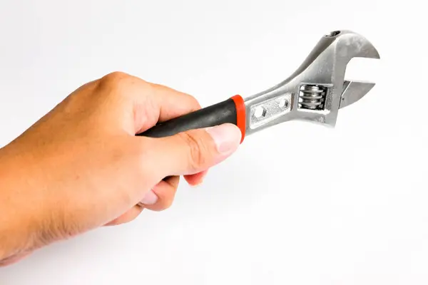 stock image Partial view of man holding a adjustable Monkey Wrench or spanner with a handle covered in black. Hand tool designed for efficient tightening and loosening tasks. Isolated on white background