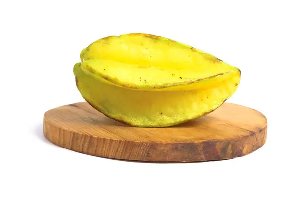 stock image Close up delicious ripe starfruit (Belimbing) on round wooden base. (Averrhoa carambola, star apple, starfruit). Isolated on white background with clipping path